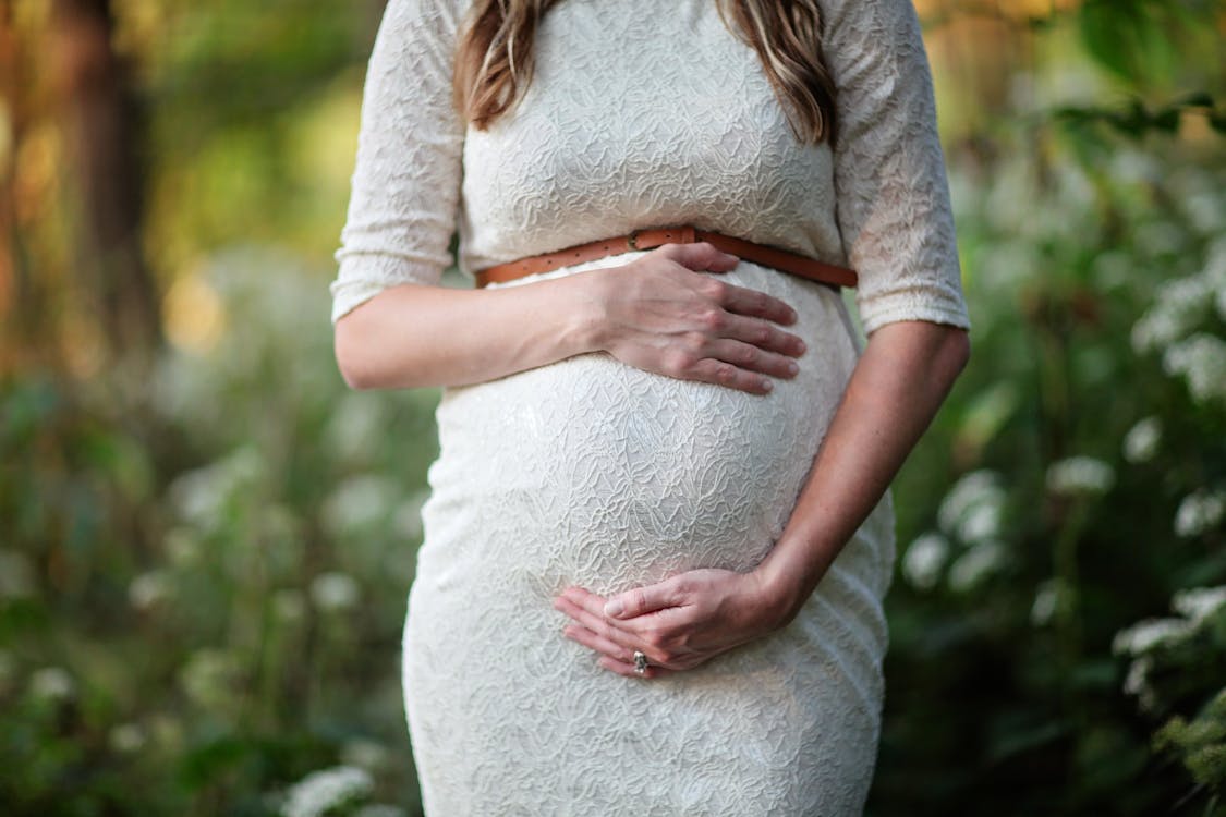 Pregnant woman holding belly in third trimester