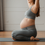 Pregnant woman doing prenatal yoga with maternity support belt